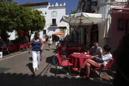 Algunos turistas se refrescan sentados en una terraza de la plaza de los Naranjos, en Marbella (Málaga). EFE/Archivo