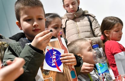 Niños de la comunidad bosnia de Jezero, lugar que comparte su nombre con uno de los cráteres de Marte, juegan con calcomanías de la NASA.