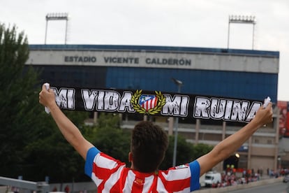 Un aficionado porta una bufanda del atlético llegando al estadio Vicente Calderón.