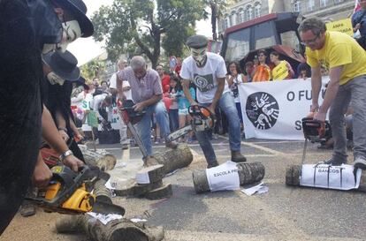 Los manifestantes cortán troncos en la protesta por los recortes 