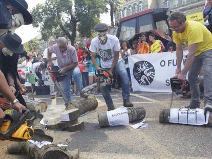 Los manifestantes cortán troncos en la protesta por los recortes
