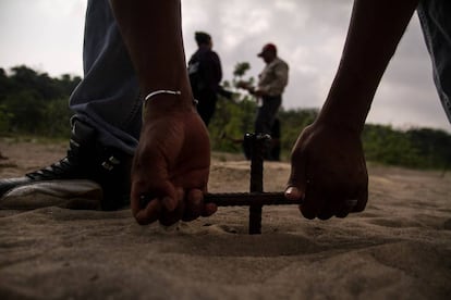 Un hombre entierra una varilla para buscar cuerpos en Colinas de Santa Fe, Veracruz.