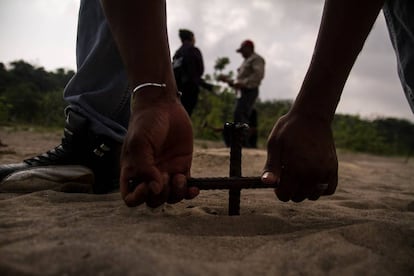 Un hombre entierra una varilla para buscar cuerpos en Colinas de Santa Fe, Veracruz. 