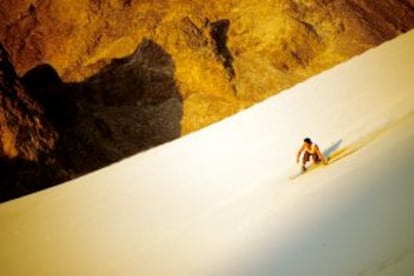 Descida de sandboard no deserto peruano.