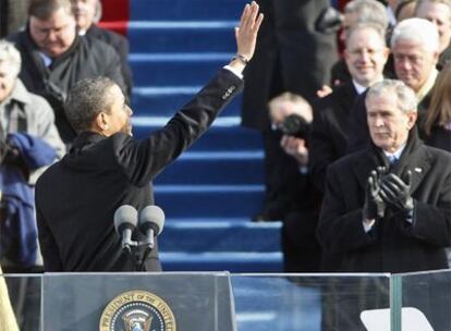 El presidente de EE UU, Barack Obama, saluda tras pronunciar su discurso de investidura. En la tribuna, George W. Bush, presidente saliente, y Bill Clinton.