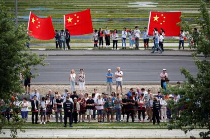 La gente sostiene banderas chinas durante la visita del primer ministro chino, Li Keqiang, a las afueras de la cancillería en Berlín, Alemania.