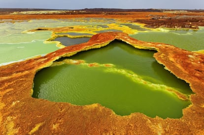 Dallol significa literalementre disolución o desintegración, un nombre muy adecuado para este multicolor paisaje formado por verdes manchas de agua sulfurosa (el color lo causan las algas), azufre y llanuras de sal. Una extravagante sinfonía de amarillos, naranjas y verdes. El cráter de Dallol, situado en la depresión etíope de Danakil, es relativamente joven, se creó durante unas erupciones de 1926.