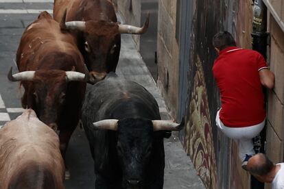 Un mozo esquiva a los astados durante el octavo y último encierro de los Sanfermines.