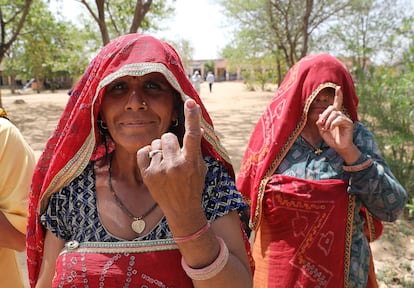 Dos mujeres indias enseñan sus dedos marcados tras votar en un colegio electoral en el pueblo de Shahpura, a las afueras de Jaipur (India), este viernes.