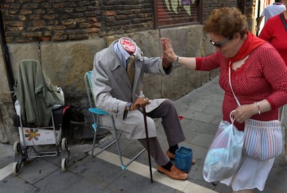 Una mujer saluda a un artista callejero durante las fiestas, el 8 de julio de 2016.