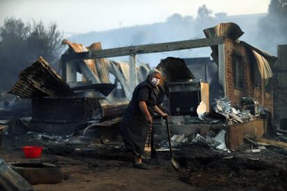 Cinco brigadas de la Corporación Nacional Forestal (CONAF) y 49 unidades de Bomberos de Valparaíso y Viña del Mar están combatiendo el incendio, con apoyo aéreo de 10 aeronaves que han tenido que paralizar su trabajo al caer la tarde. En la imagen, Nora Villarroel de 59 años, junto a los restos de su casa quemada.