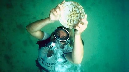 Un buceador muestra un plato de oro hallado en el galeón español 'Santa Margarita'.