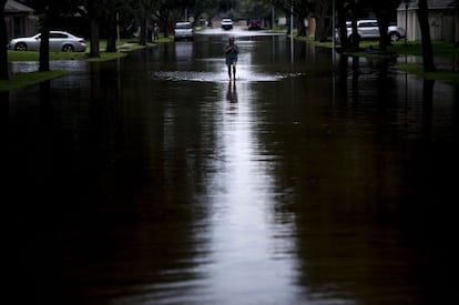 Una mujer recorre una calle inundada en Houston.