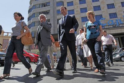 Tomás Gómez, la portavoz regional Maru Menéndez y el senador Enrique Cascallana cruzan la Gran Vía de Madrid ayer por la mañana.