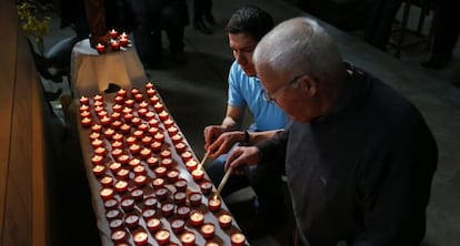 Dos asistentes encienden velas durante la misa celebrada en Digne-les-Bains.