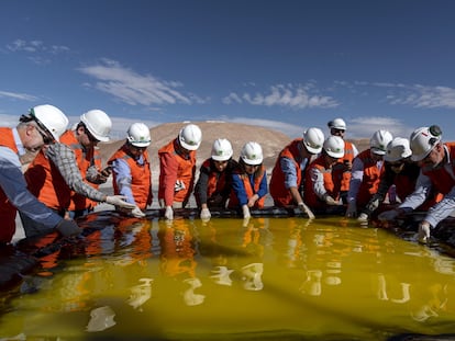 Visitantes inspeccionan una piscina de salmuera en una mina de litio en el desierto de Atacama, Chile.