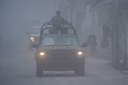 Elementos del Ejército mexicano patrullan las calles cubiertas de ceniza de Santiago Xalitzintla.