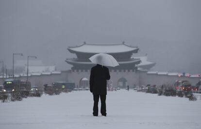 Un hombre se protege de la nieve con un paraguas, cerca de Gwanghwamun, la puerta principal del Palacio Gyeongbok, uno de los lugares emblemáticos de Seúl (Corea del Sur).