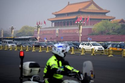 Um policial patrulha com sua moto nas imediações da Praça Tiananmen, em Pequim.