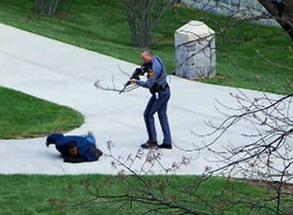 Un policía apunta con su arma a un joven en el campus de la Universidad Virginia Tech. Instantes después de la matanza, la policía retenía a cualquiera que pudiera ser sospechoso de haber cometido la masacre aunque después se ha sabido que el presunto asesino se ha quitado también la vida.