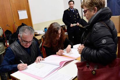 Una mujer prepara su voto en un centro electoral de Milán.