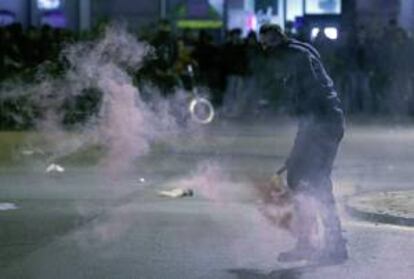 Un joven se dispone a lanzar una bengala contra los Mossos d'esquadra durante los enfrentamientos registrados al finalizar la marcha convocada por las centrales CGT y CNT, en Barcelona.