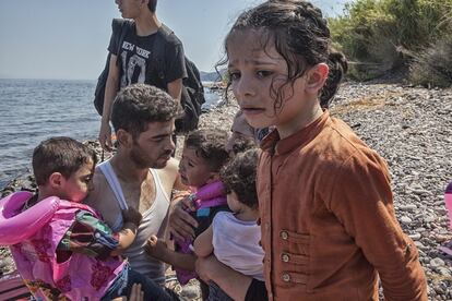 Un hombre consuela a sus hijos momentos después de desembarcar en la costa norte de la isla Lesbos tras cruzar el Mar Egeo en un una barca de plástico. Según Unicef, uno de cada 200 niños en el mundo ha tenido que huir de su hogar por la guerra y otros conflictos.