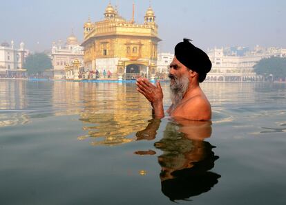Un devoto sij se baña en el estanque del Templo de Oro, el más sagrado de los lugares de su religión, durante el 551º aniversario del nacimiento de Sri Guru Nanak Dev Ji, el primer gurú sij, en Amritsar (India).
