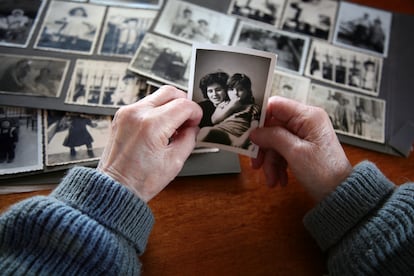 Una mujer observa una foto antigua de ella con su hija.