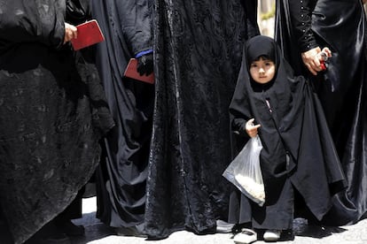 Una niña hace cola junto a su madre para poder votar en las urnas habilitadas en el lugar sagrado de Abdol Azim en la población de Shahre-Ray, al sur de Teherán, capital de Irán.