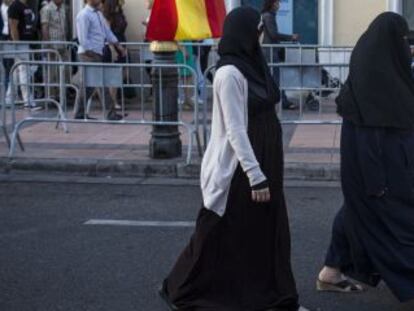 Mujeres musulmanas caminan por la Avenida Rey Juan Carlos I de Melilla, al acabar un desfile militar el pasado junio.