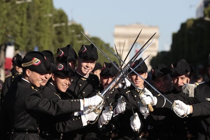Alumnos de la Escuela Politécnica muestran sus espadas mientras esperan el inicio del desfile militar anual del Día de la Bastilla en la avenida de los Campos Elíseos.