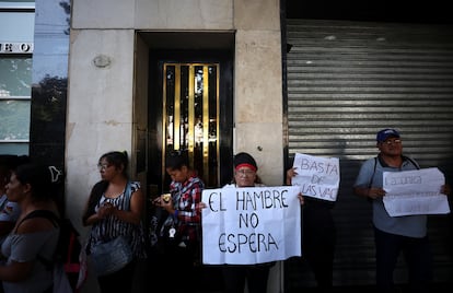Personas llevan carteles en protesta contra el hambre, afuera del ministerio de Capital Humano, este lunes en Buenos Aires.
