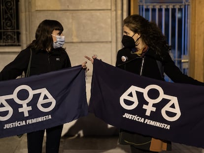 Dos concentradas frente al Ayuntamiento de Igualada muestran pancartas con el lema "justicia feminista".