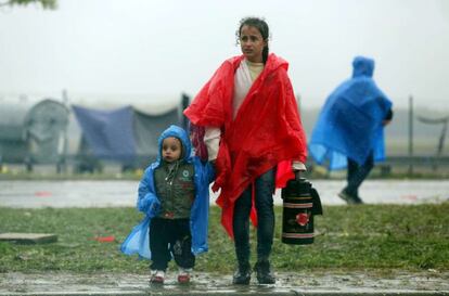 Duas crianças esperam na fronteira entre Croácia e Eslovênia, nesta segunda-feira.