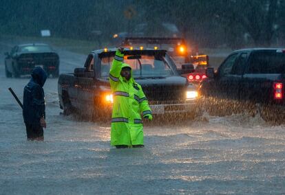 Floodwaters surround vehicles and people after heavy rain in Leominster, Massachusetts, U.S., September 11, 2023