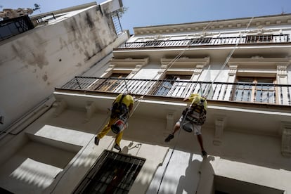 Operarios trabajan en la fachada de un edificio hoy en Sevilla.