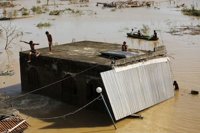 Unos niños saltan al agua desde el tejado de un edificio en una zona dañada por el tifón Haima, en Tuguegarao, provincia de Cagayan (Filipinas).