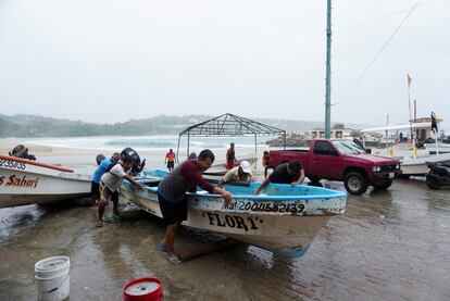 Pescadores sacan sus botes del agua en Puerto Escondido, Oaxaca mientras se acerca el huracán Agatha a la costa del sur de México, este lunes 30 de mayo.