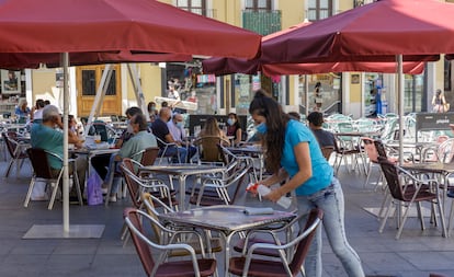 Una camarera limpia una mesa del bar El largo adiós de Valladolid.