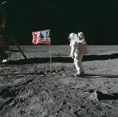 El astronauta Edwin E. Aldrin Jr., piloto de la primera misión de aterrizaje lunar, posa para una fotografía junto a la bandera de Estados Unidos desplegada en la superficie lunar, el 20 de julio de 1969. En el suelo se pueden apreciar las huellas de los primeros astronautas en pisar la luna. El comandante Neil A. Armstrong tomó esta fotografía con una cámara de superficie lunar Hasselblad de 70 mm.
