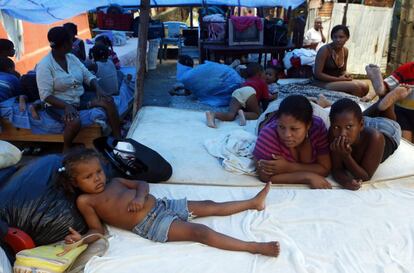 Una familia bajo una lona tras perder su casa debido a la crecida del río Ozama, en República Dominicana.