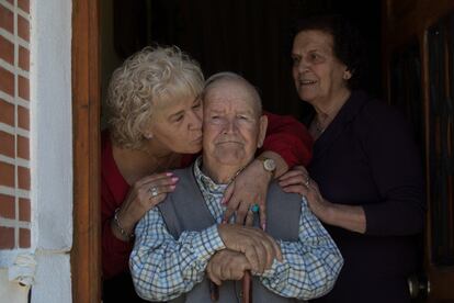 Aquel bebé es hoy un hombre de 83 años que vive en una casa humilde de la calle principal de Cevico de la Torre, una localidad con unos 400 habitantes. Habla poco, tiene la mirada fija y unas manos muy anchas de toda una vida trabajando, pues empezó a los ocho años. En la imagen, Martín de la Torre Muñoz posa en la puerta de su vivienda junto a su hija, Martina de la Torre Atienza, que le da un beso, y su mujer, Francisca Atienza Ocasar.