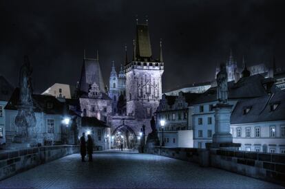 Una pareja pasea por el Puente Carlos de la ciudad de Praga (República Checa).