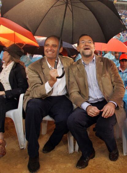 Camps cubre con un paraguas a Rajoy en un mitin en la plaza de toros de Valencia, durante la campaña a las elecciones autonómicas de 2007.