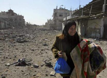 Una mujer palestina traslada sus pertenencias por una calle bombardeada de Rafah, al sur de la franja de Gaza.