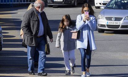 Paula Echevarría, con su hija, graba a los paparazis ayer a la salida de un hospital de Madrid.