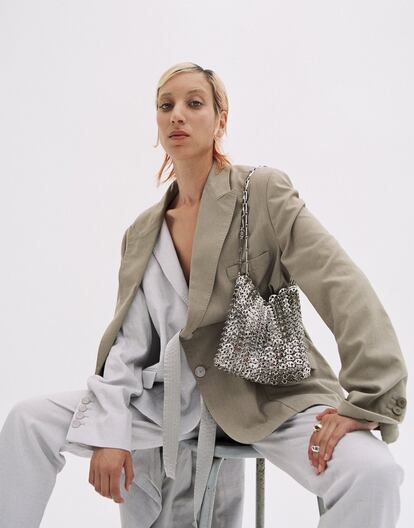 Traje de chaqueta gris claro en algodón de Stella McCartney, chaqueta de Mango; bolso Icono 1969 color plateado, de Paco Rabanne, y sortijas dorada y de plata de Helena Rohner.