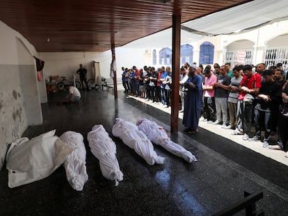 Gazatíes rezan frente a los cadáveres de los muertos en un bombardeo israelí, este viernes, en Ciudad de Gaza.