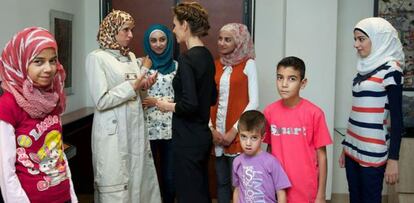 Asma el Asad, con mujeres y niños víctimas de la guerra.